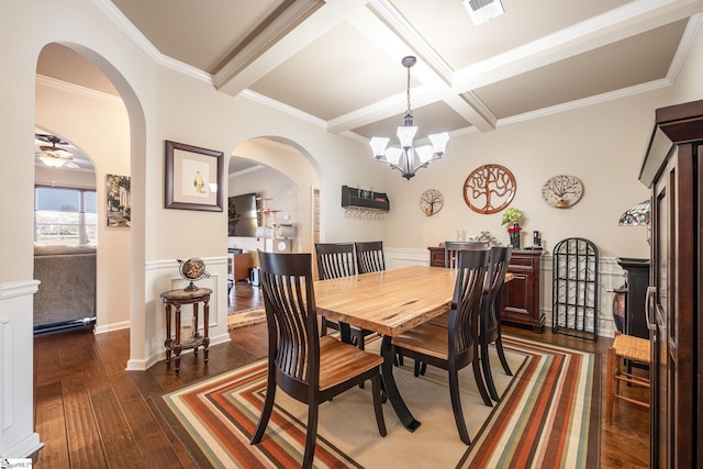 dining room with beam ceiling, dark hardwood / wood-style flooring, ceiling fan with notable chandelier, and ornamental molding