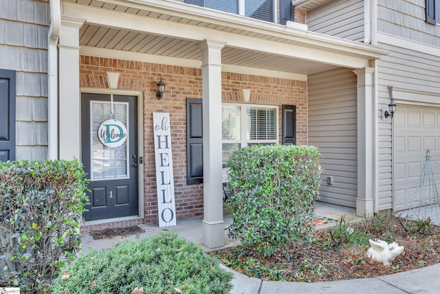 entrance to property with covered porch and a garage