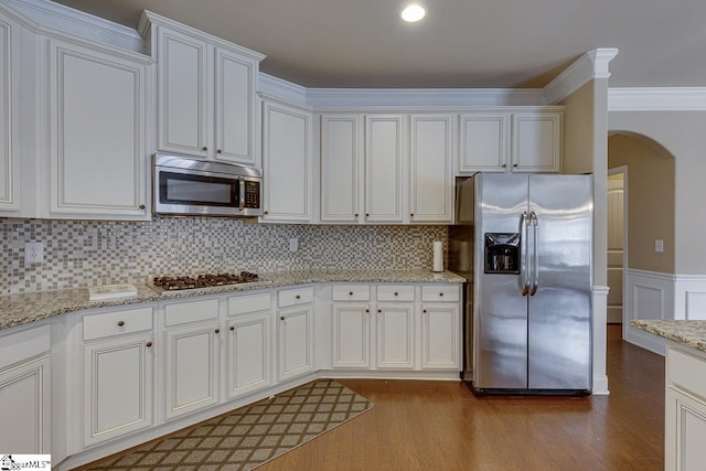 kitchen featuring backsplash, white cabinetry, stainless steel appliances, and light hardwood / wood-style floors