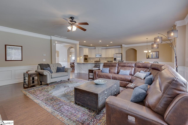 living room featuring crown molding, ceiling fan with notable chandelier, and hardwood / wood-style flooring