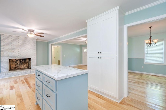 kitchen featuring a fireplace, light hardwood / wood-style flooring, white cabinets, and a kitchen island