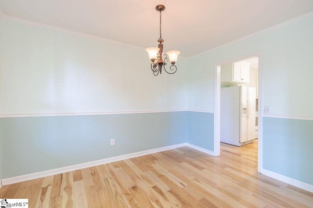 empty room with an inviting chandelier, light hardwood / wood-style flooring, and ornamental molding