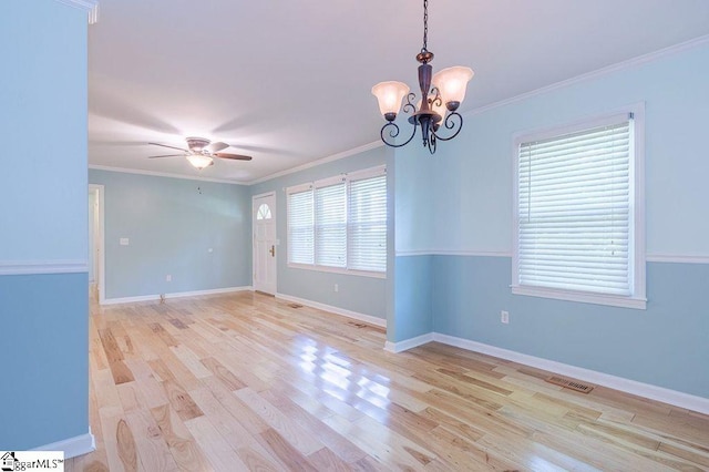 empty room featuring ceiling fan with notable chandelier, light hardwood / wood-style floors, and ornamental molding