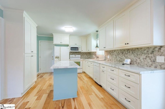 kitchen featuring a center island, hanging light fixtures, white appliances, and light hardwood / wood-style floors