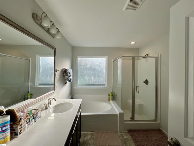 bathroom featuring vanity, shower with separate bathtub, and a wealth of natural light