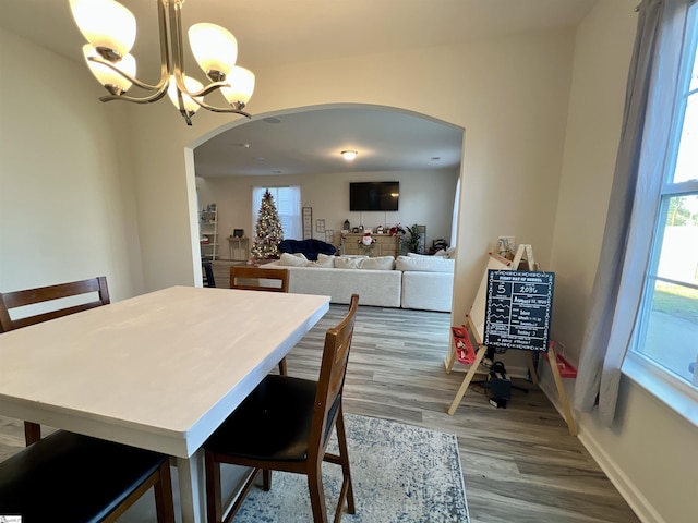 dining space featuring hardwood / wood-style floors and an inviting chandelier