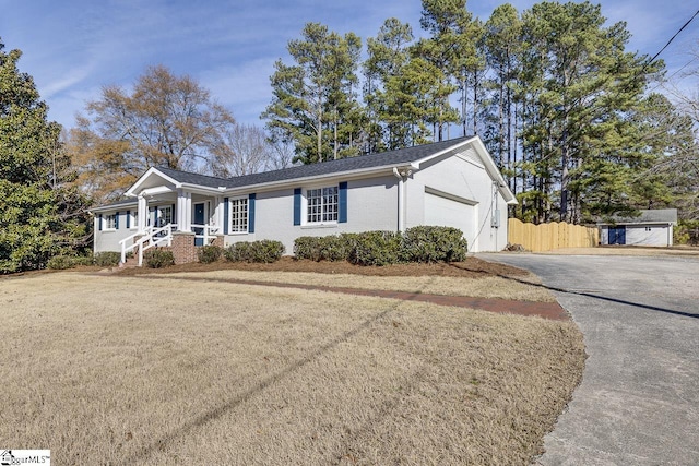 ranch-style house featuring a garage and a front lawn