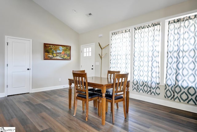 dining area featuring high vaulted ceiling and dark wood-type flooring