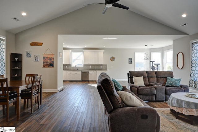 living room with dark hardwood / wood-style floors, sink, ceiling fan with notable chandelier, and high vaulted ceiling