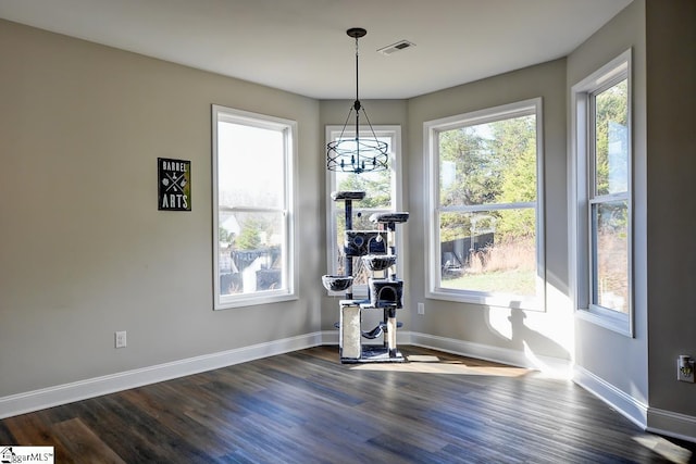 unfurnished dining area featuring dark wood-type flooring