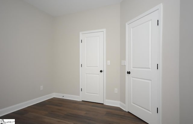 spare room with dark wood-type flooring