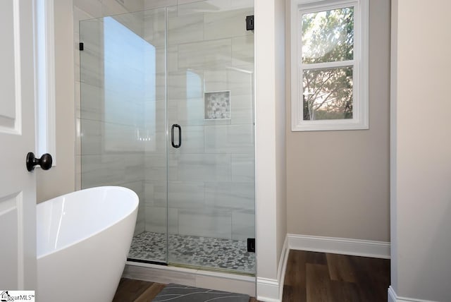 bathroom with independent shower and bath and hardwood / wood-style flooring