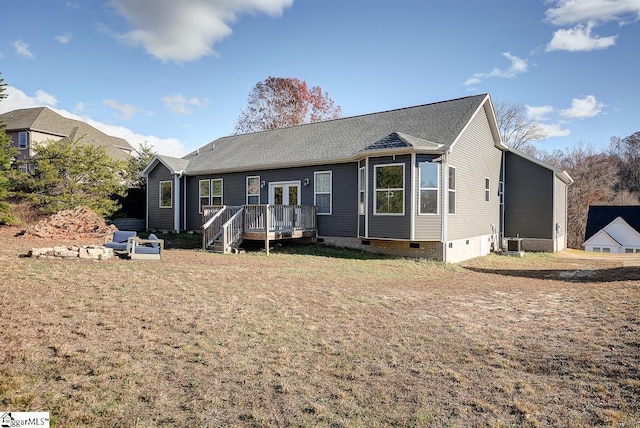 rear view of house featuring a deck and a lawn