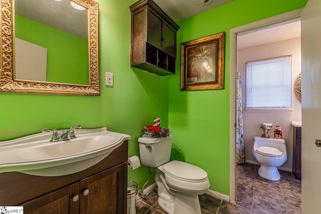 bathroom with vanity, a textured ceiling, and toilet