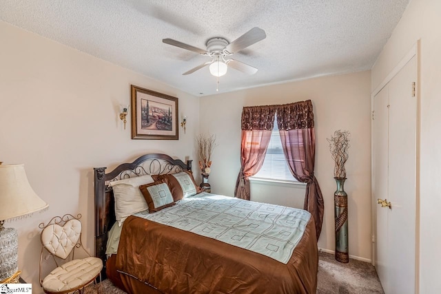 carpeted bedroom featuring a textured ceiling and ceiling fan