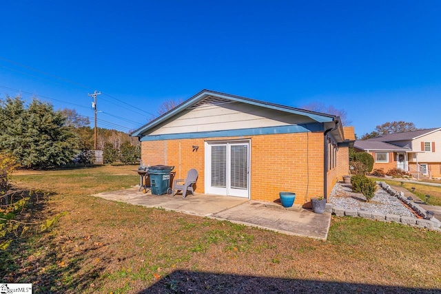 back of property with a patio area and a yard