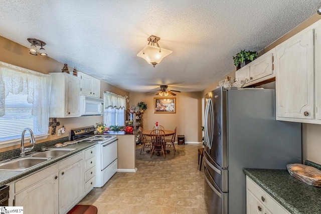 kitchen with white cabinets, a textured ceiling, white appliances, and sink