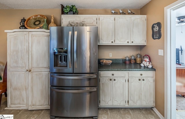 kitchen featuring stainless steel refrigerator with ice dispenser and a textured ceiling