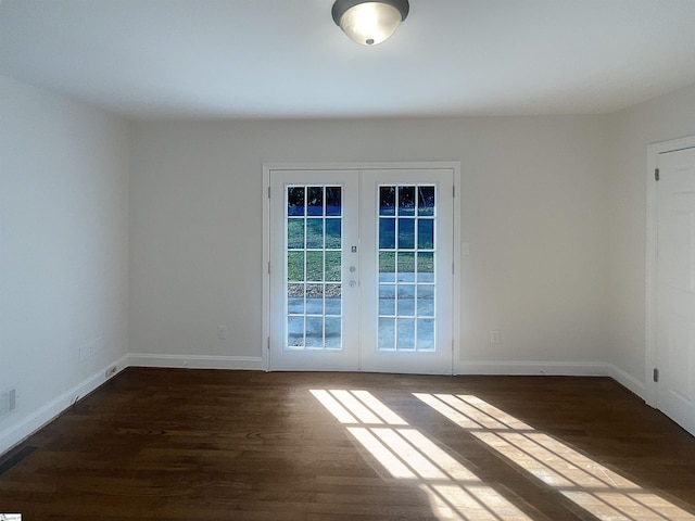 spare room with french doors and dark wood-type flooring