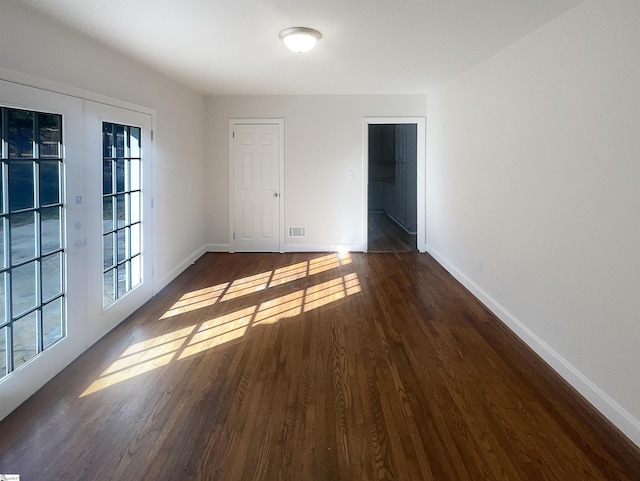 empty room featuring dark wood-type flooring and french doors