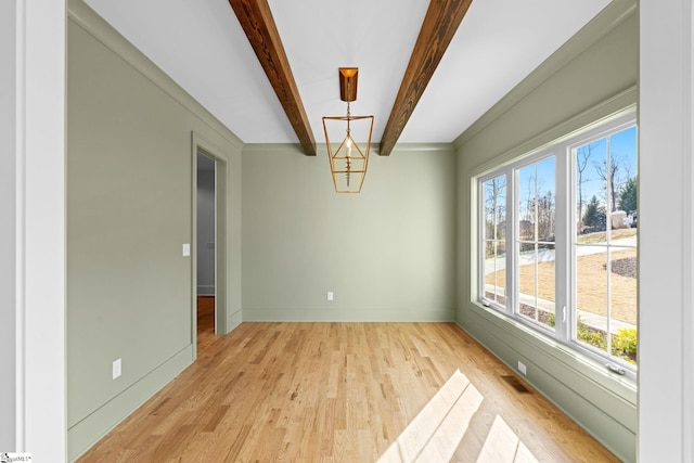 unfurnished dining area with beam ceiling and light wood-type flooring