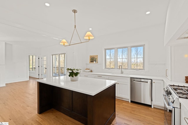 kitchen with a center island, a healthy amount of sunlight, sink, and stainless steel appliances