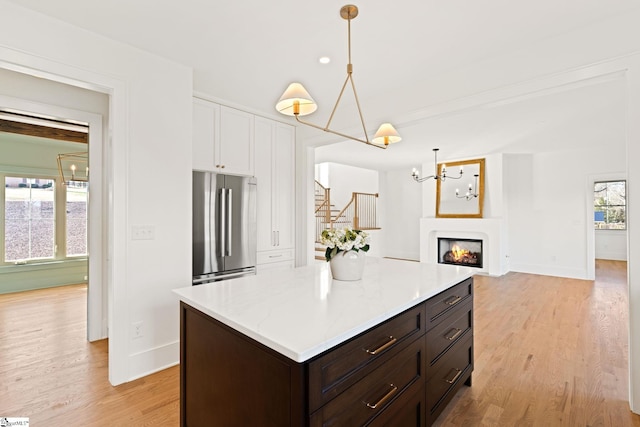 kitchen with stainless steel refrigerator, a wealth of natural light, and light wood-type flooring