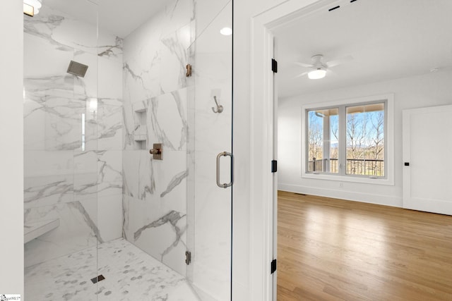 bathroom featuring hardwood / wood-style flooring, ceiling fan, and walk in shower