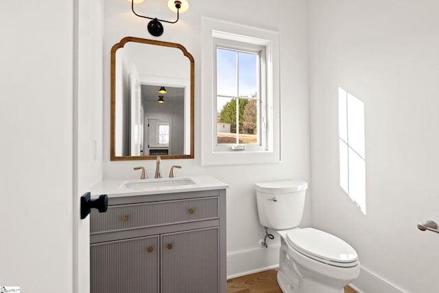 bathroom featuring hardwood / wood-style flooring, vanity, and toilet