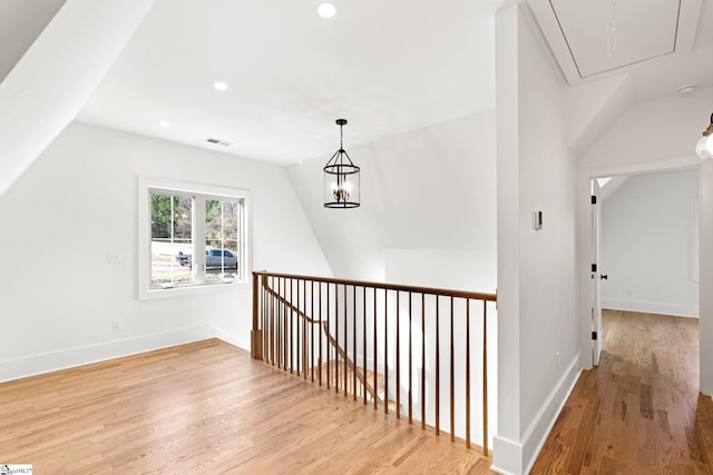 corridor with light hardwood / wood-style flooring and lofted ceiling