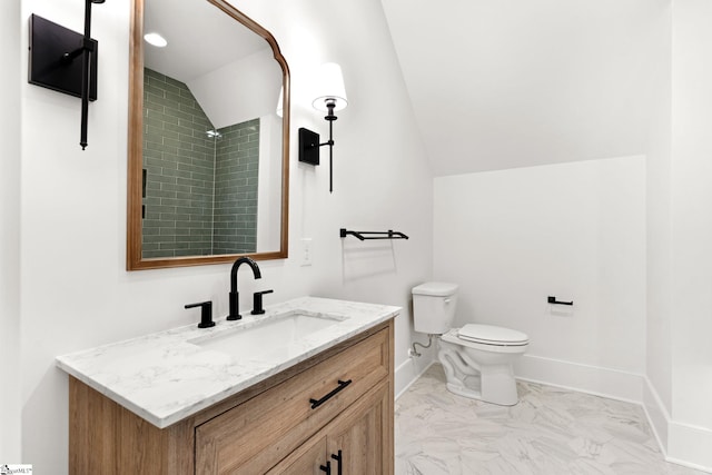 bathroom featuring toilet, vanity, and vaulted ceiling