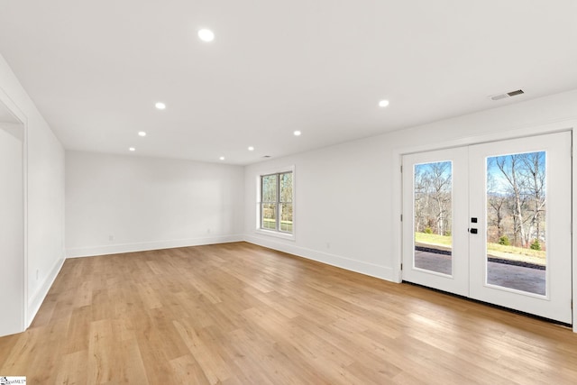 spare room with french doors and light hardwood / wood-style floors