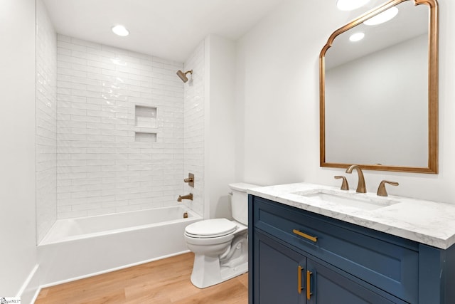 full bathroom with toilet, vanity, tiled shower / bath combo, and hardwood / wood-style flooring