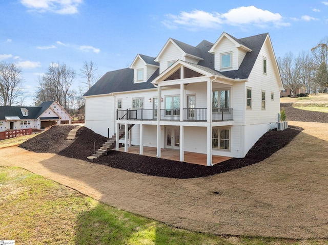 rear view of house with french doors, a patio, a balcony, and central AC unit