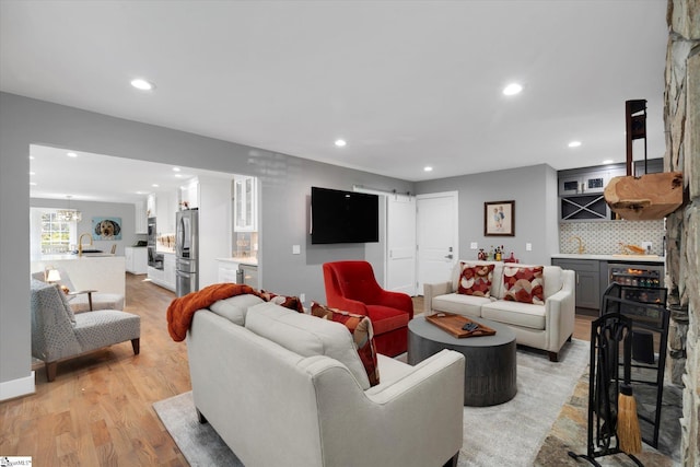 living room with sink and light hardwood / wood-style flooring