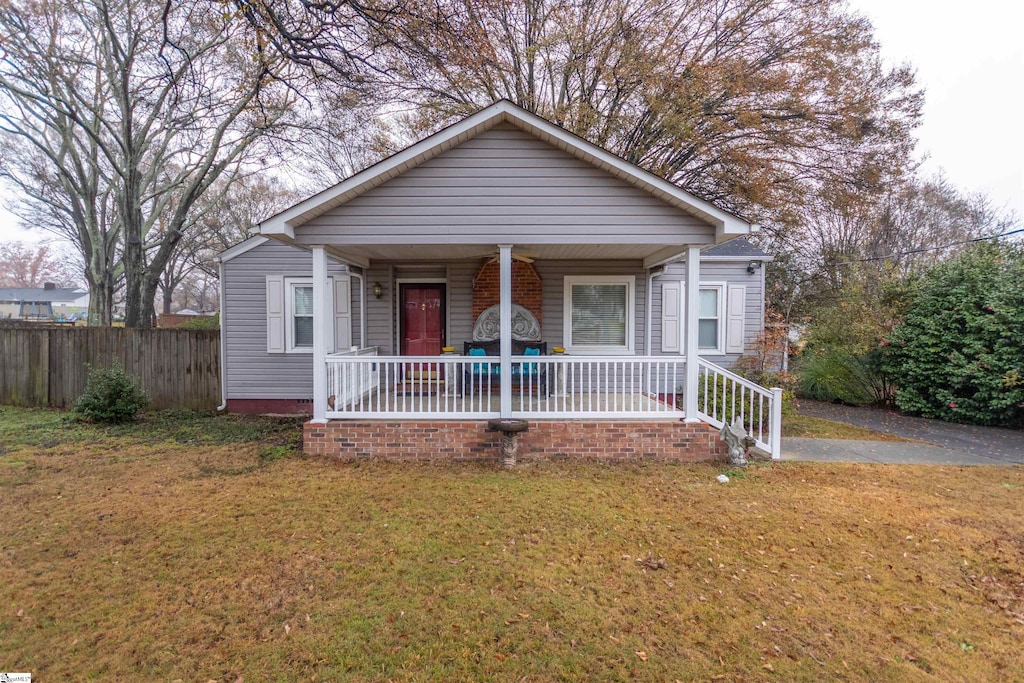 bungalow-style home featuring a front yard and covered porch