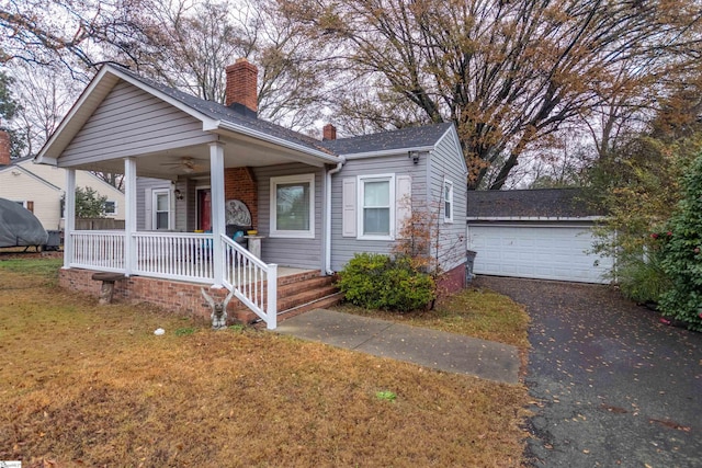 bungalow-style home featuring covered porch, a garage, and a front lawn