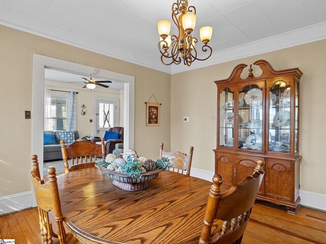 dining room featuring ceiling fan with notable chandelier, light wood-type flooring, and ornamental molding