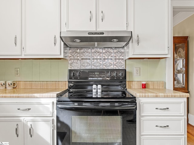 kitchen with white cabinets, black range with electric stovetop, backsplash, and ornamental molding