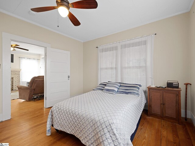 bedroom featuring hardwood / wood-style flooring, ceiling fan, and crown molding