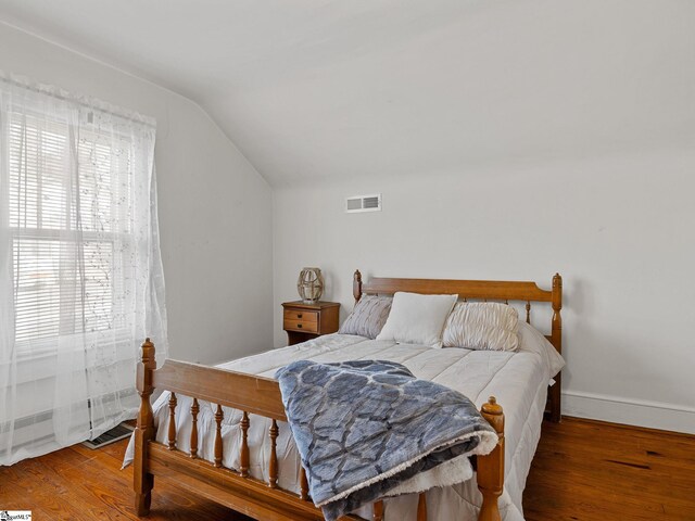 bedroom featuring wood-type flooring and vaulted ceiling