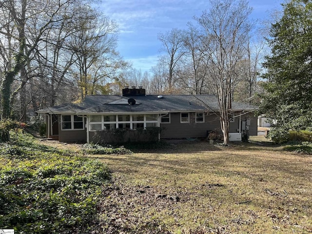 rear view of property with a sunroom and a yard