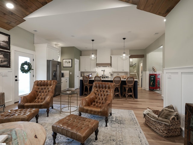 living room with light wood-type flooring and vaulted ceiling