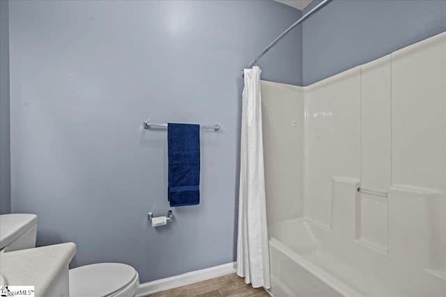 bathroom with shower / bathtub combination with curtain, toilet, vanity, wood finished floors, and baseboards