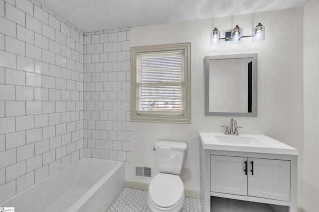 full bathroom featuring tile patterned floors, vanity, a textured ceiling, tiled shower / bath combo, and toilet