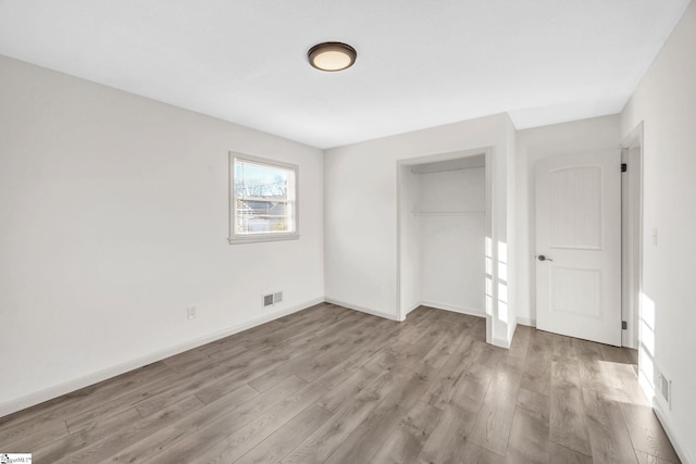 unfurnished bedroom with light hardwood / wood-style floors and a closet