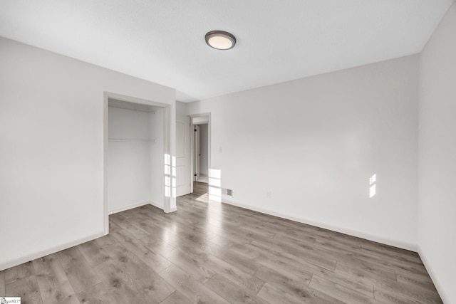 unfurnished bedroom featuring a closet and light hardwood / wood-style flooring