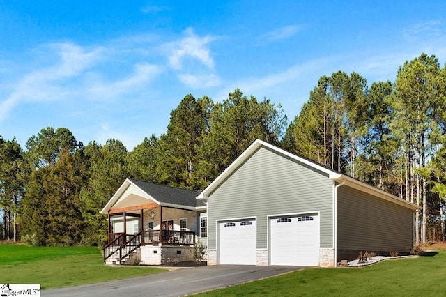 exterior space featuring a front lawn, a porch, and a garage