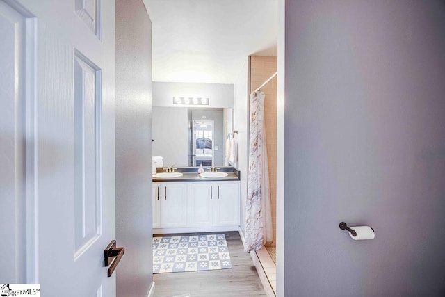 bathroom featuring vanity, wood-type flooring, and walk in shower