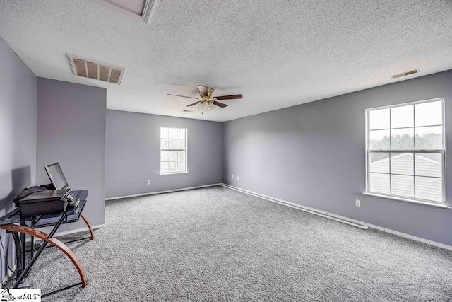 spare room with carpet flooring, a textured ceiling, and ceiling fan